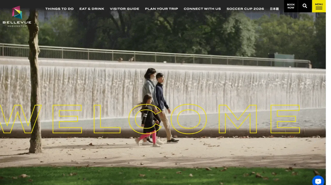 The Visit Bellevue homepage: the word “Welcome” in large outlined letters over a photo of a family walking past a waterfall.